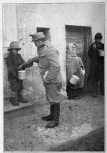 Photograph from Henry Ruschin
AUSTRIAN SOLDIER IN CARPATHIANS GIVING HUNGRY YOUNGSTER
SOMETHING TO EAT
Moved by the misery of the civilian population the soldiers will often share their
rations with them. An Austrian soldier in this case shares his food with a boy in a
small town in the Carpathian Mountains, Hungary.